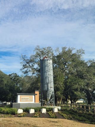 A picturesque view of Granary Park by Lennar featuring a silo and lush greenery, located in Green Cove Springs, FL.