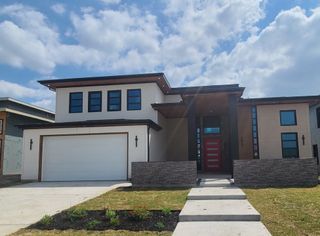 Street view A modern two-story home with a striking red door in The Dawn by NETZE.HOMES (Melissa, TX).