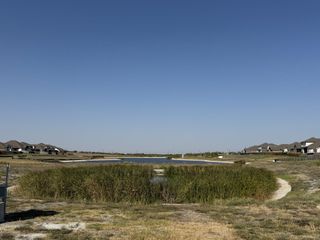 Community Amenities A scenic pond with a walking trail in Blackhawk by GFO Home (Pflugerville, TX), offering peaceful views and nature-filled relaxation.
