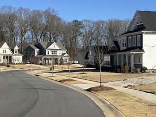 Street view Charming homes with inviting porches and manicured lawns in McLean South Shore by Tri Pointe Homes (Belmont, NC).