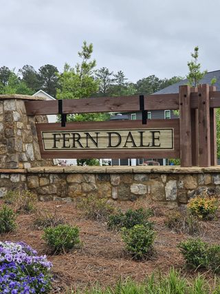 A welcoming entry sign with rustic stone accents at Fern Dale by Dream Finders Homes in Fairburn, GA.