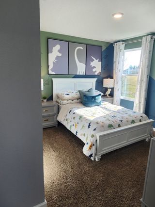 A cozy bedroom with soft carpeting, a decorative accent wall, and natural light in Copes Landing by D.R. Horton (Jacksonville, FL).