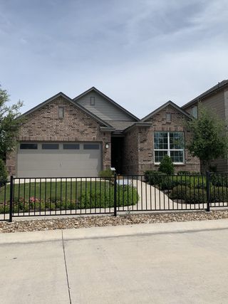 Street view A charming brick home in Sonterra - Cool Water by KB Home, featuring a manicured lawn and modern design (Jarrell, TX).