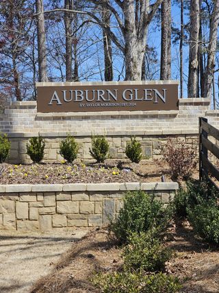 Elegant stone entrance with manicured landscaping welcomes you to Auburn Glen by Taylor Morrison in Dacula, GA.