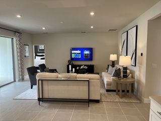 Model Home Modern living room with sleek furniture, wall art, and soft lighting creating a cozy, inviting ambiance.