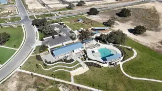 Model Home Aerial view of community amenities, including a pool and playground in Lariat 45' by Perry Homes (Liberty Hill, TX).