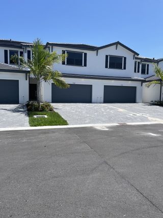 Modern white townhomes with sleek black shutters and palm landscaping in Dania Preserve by Lennar (Fort Lauderdale, FL).