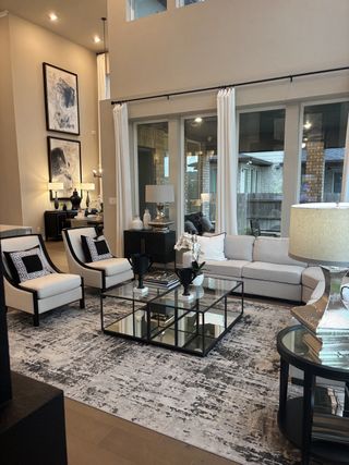 A grand living room with soaring ceilings, expansive windows, and a stylish neutral color palette for an inviting ambiance.