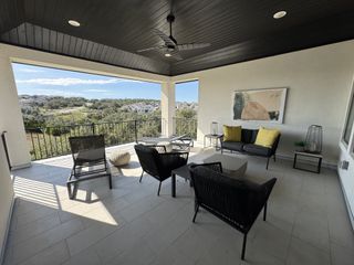 A spacious covered patio with modern outdoor furniture, offering a stunning view of the surrounding landscape and a relaxing outdoor living space.