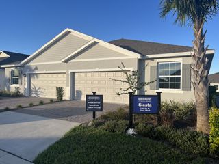 Street view A modern duplex with elegant shutters and manicured landscaping in Ocala Preserve by D.R. Horton (Ocala, FL).