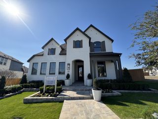 A stylish white brick home with elegant shutters and manicured landscaping in Weston Oaks by Highland Homes (San Antonio, TX).