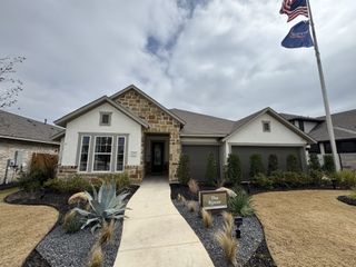 A charming stone-brick home with manicured landscaping in Meyer Ranch by David Weekley Homes (New Braunfels, TX).