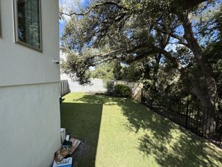 A charming backyard with lush grass and shade trees in Wolf Ranch - 60' by Drees Custom Homes (Georgetown, TX).