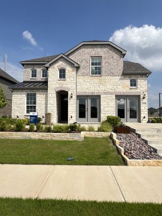 Street view A beautiful stone façade home with modern design in Wilson Creek Meadows by Pulte Homes (Celina, TX).