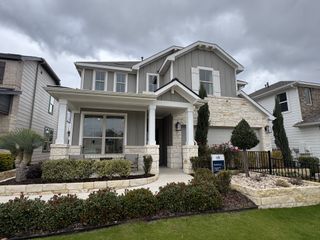 A charming two-story home with stone accents and lush landscaping in Horizon Lake by Pulte Homes (Leander, TX).