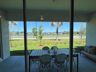 Model Home A serene patio with a dining set overlooks lush greenery and a scenic view, perfect for relaxation and outdoor dining.