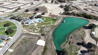 Expansive community view with a serene pond and pathways at Lariat 60' by Perry Homes in Liberty Hill, TX.