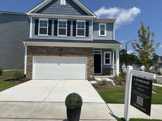 Model Home A charming two-story home with stone accents and lush landscaping in Harlowe Point by Lennar (Durham, NC).