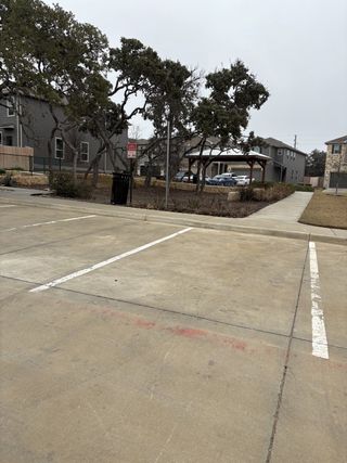 Community Amenities A clean and convenient parking lot adjacent to a green space and playground within the Cove at Westover Hills community by KB Home (San Antonio, TX).