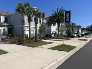 A welcoming townhome model with a stylish gray facade and lush landscaping in Bridgewater by D.R. Horton (St. Augustine, FL).
