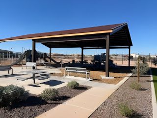 Community Amenities A modern outdoor pavilion with seating and a playground in North Copper Canyon by Oakwood Homes Co (Surprise, AZ).