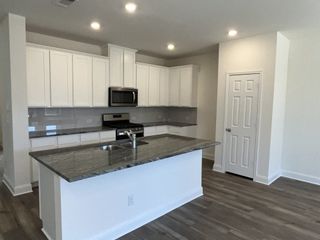 A bright and airy kitchen with white cabinetry, granite countertops, and a spacious island, perfect for entertaining and meal prep.