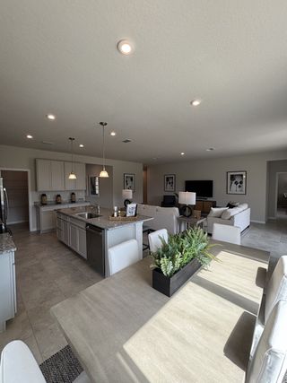 A modern, open-concept home with a spacious and elegant design. The home features a seamless flow between the kitchen, dining, and living areas, creating a bright and airy atmosphere. 