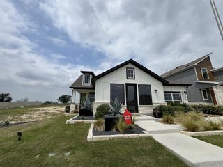 Street view A charming modern farmhouse with landscaped yard in Willowbrook by Scott Felder Homes (New Braunfels, TX).