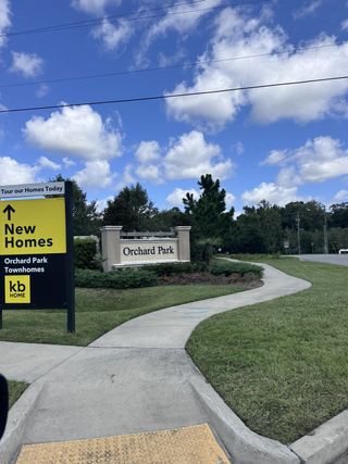 Welcome to Orchard Park Townhomes by KB Home in St. Augustine, FL, featuring lush greenery and inviting pathways.