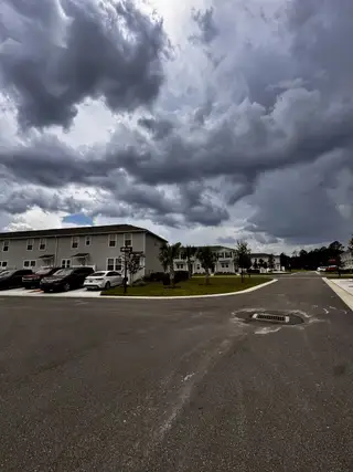 Modern townhomes with ample parking under dramatic skies in RiverTown - Meadows by Mattamy Homes (St. Johns, FL).