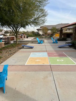 A vibrant community play area with colorful games and seating in Sierra at Alamar by David Weekley Homes (Avondale, AZ).
