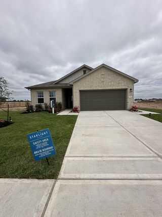 A modern brick home with a neat driveway in the Royal Pines community by Starlight Homes (Porter, TX).