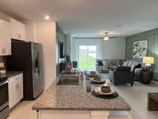 A spacious open-concept kitchen and living area with granite countertops, sleek appliances, and modern decor.