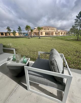 Street view A cozy outdoor patio with modern seating overlooking new constructions in Cherry Elm at SilverLeaf by Dream Finders Homes (St. Augustine, FL).