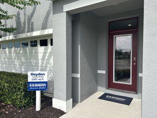 A modern gray home with sleek red door in Timberwalk by D.R. Horton (Mount Dora, FL).