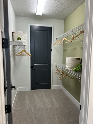 A modern walk-in closet with sleek shelving, neutral walls, and ample hanging space, featuring stylish baskets and hangers.