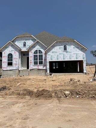 A home under construction in Parkside On The River by Highland Homes, showcasing the early stages of building in Georgetown, TX.