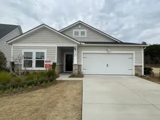 Street view A charming gray home with a manicured lawn and two-car garage in Horizons at Summers Corner by Lennar (Summerville, SC).