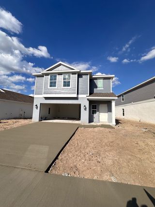 A modern open-concept kitchen with sleek white cabinetry, stainless steel appliances, and a spacious island with bar seating.