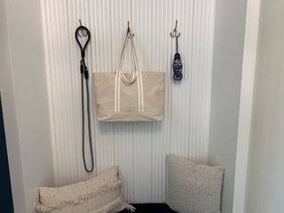 Model Home A stylish mudroom nook with textured wall hooks, cozy pillows, and organized storage. Perfect for daily essentials.