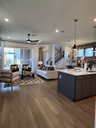 Model Home A bright open-concept living space with large windows, a cozy seating area, and contemporary lighting for effortless modern living.
