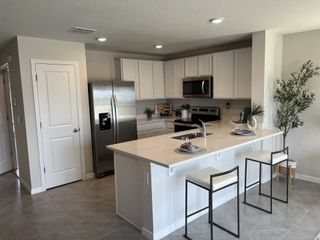 A modern kitchen with sleek stainless steel appliances, a spacious island, and elegant white cabinetry.