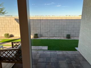 Model Home A cozy patio with elegant paving, neat artificial turf, and a privacy wall, perfect for relaxation.