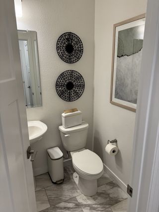 A modern bathroom with sleek fixtures, artistic wall décor, and a clean, minimalist aesthetic.
