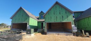 A modern new build with gable roofs under construction in VIDA Townhomes by Sitterle Homes (San Antonio, TX).
