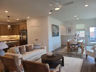 Model Home A cozy living-dining area with a modern kitchen, neutral tones, and elegant lighting.
