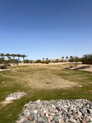 Expansive green space with palm trees in West Santa Rosa Springs by K. Hovnanian® Homes (Maricopa, AZ).