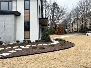 A sleek, modern home with unique textures and minimal landscaping in North Hills by Homestead Building Company (Raleigh, NC).
