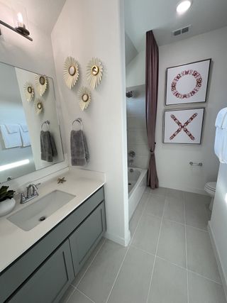 A chic bathroom with modern accents, a sleek vanity, and artistic decor. Perfect blend of style and functionality.