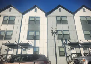 A row of completed townhomes with sleek gray and white exteriors, offering stylish urban living in Johnson Commons by Breeze Homes (Jacksonville, FL).